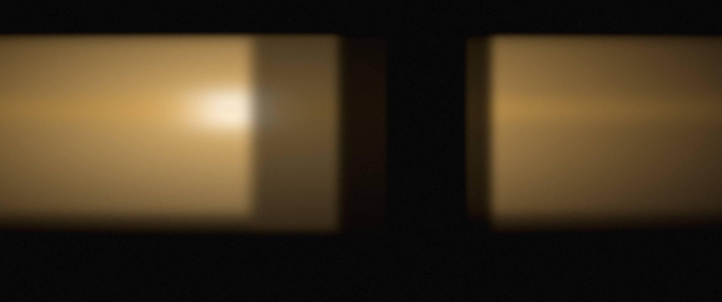 An auditorium lit by warm stage light, audience in silhouette.