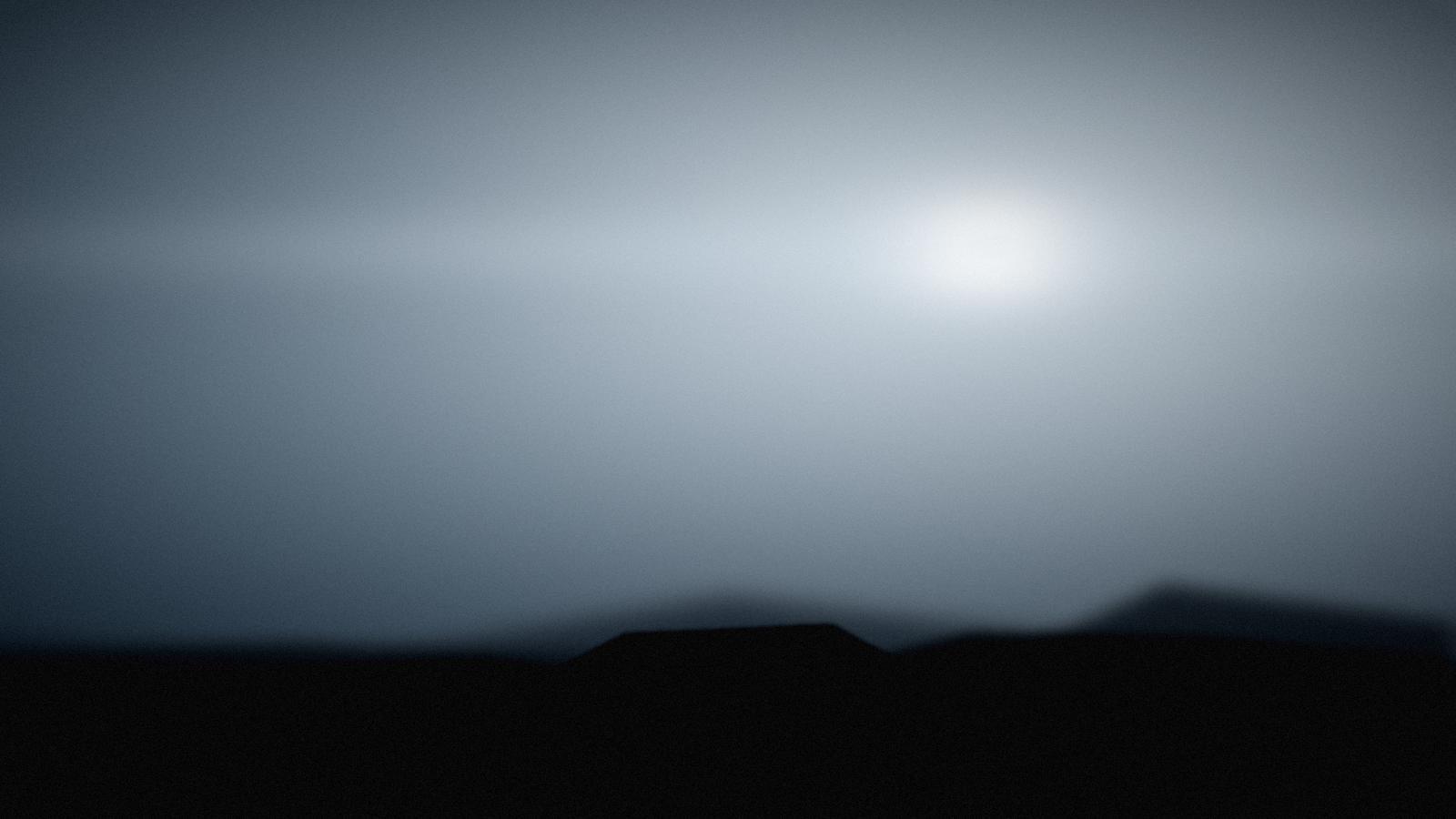 Silver storm light over a coastal ridge.
