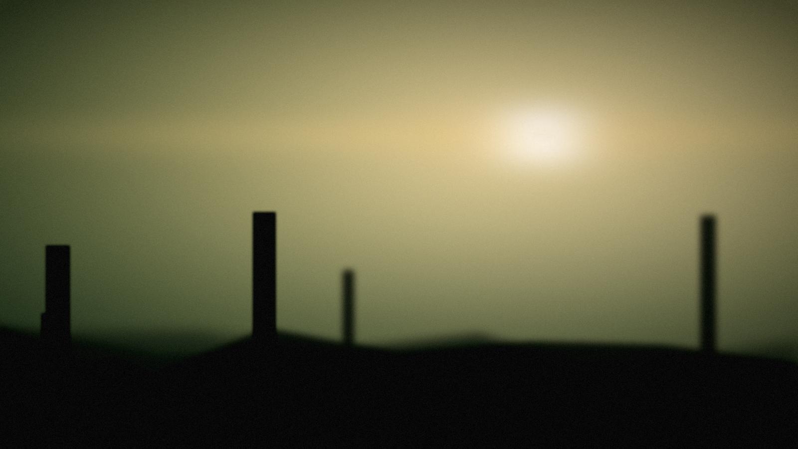 A low midsummer sun behind a ridge, warm green field in the foreground.