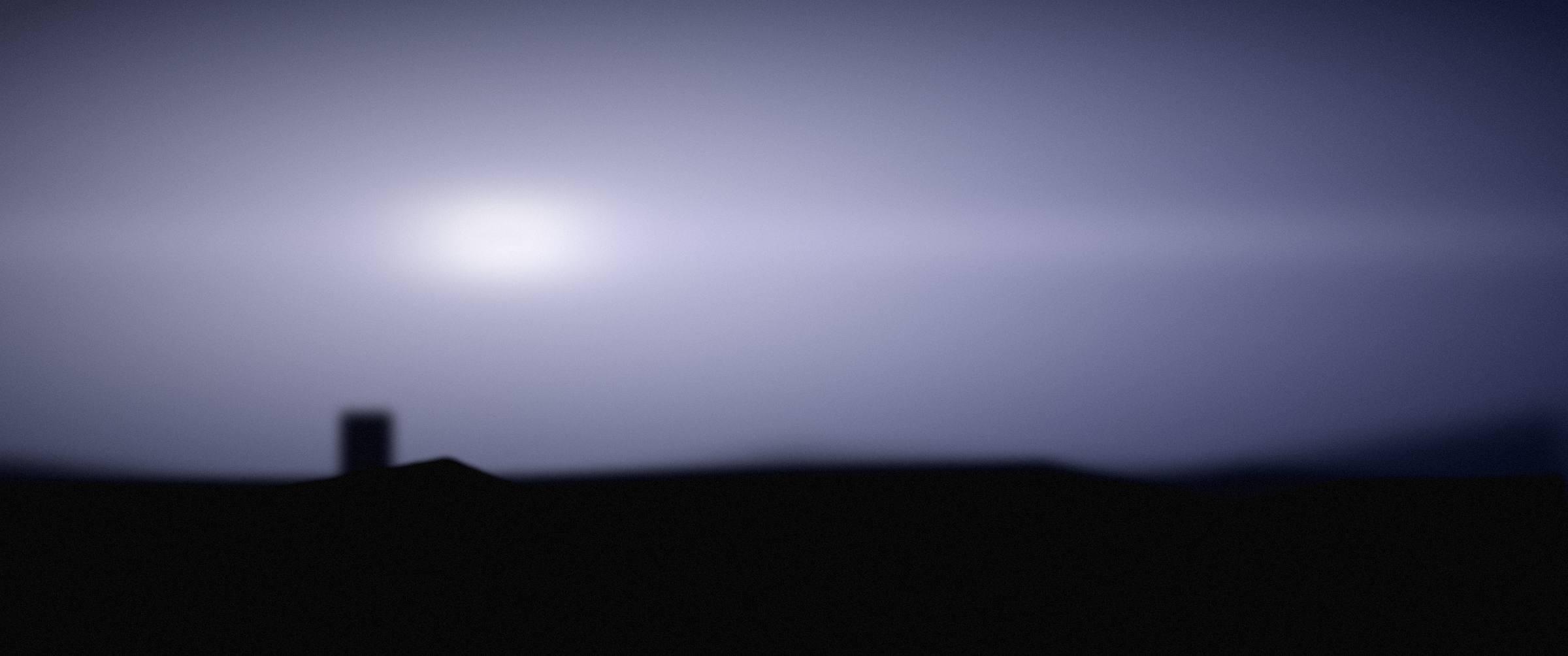 A cold blue horizon before sunrise over the city.