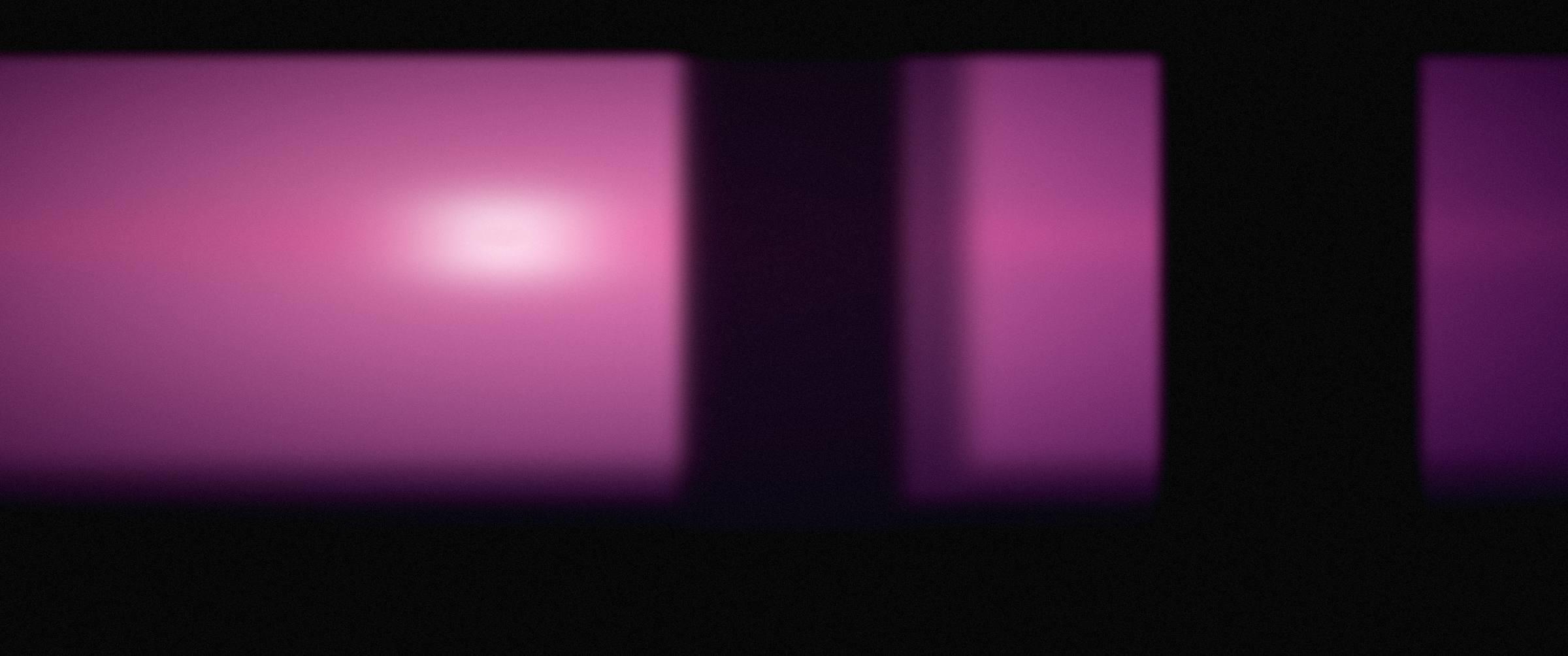 Deep magenta stage light spilling through a dark rehearsal room.