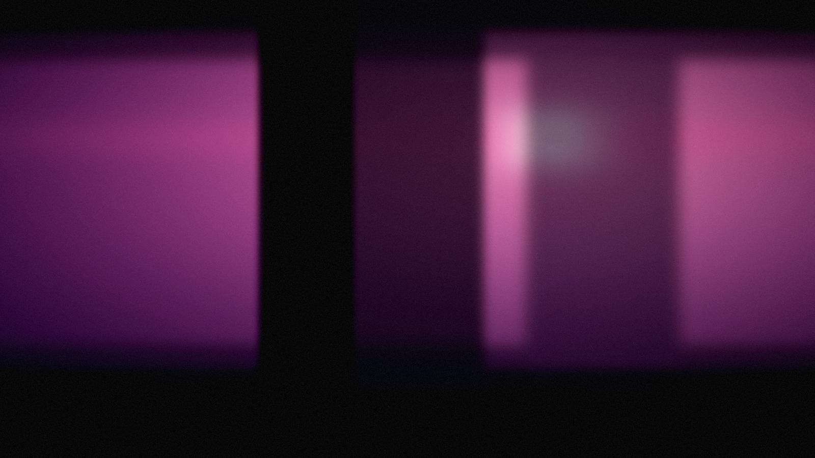 A magenta light source blooming across a dark studio interior.